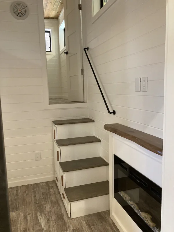 Photo of the staircase and fireplace of a tiny house built by North Andes Homes.
